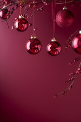 Wall Mural -  Burgundy christmas vertical background with wine colored christmas decorations and crystals hanging on fir branches with red berries on rich burgundy background with copy space