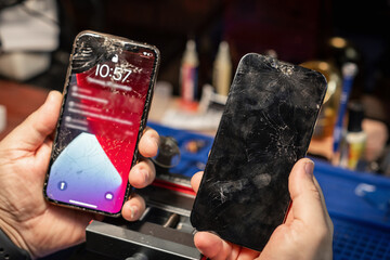 Poster - Smartphone with shattered glass is held during repair at a service center in the afternoon