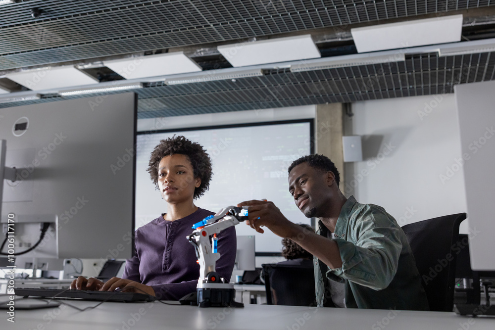 Robotics Programmer Occupation Coworkers programming a robotic arm Stock Photo | Adobe Stock