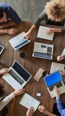 Poster - A group of people are sitting around a table with laptops and papers