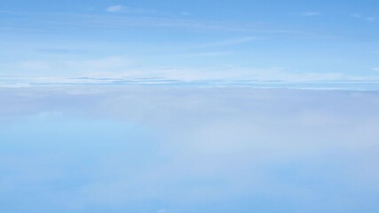Wall Mural - Aerial view above the clouds and sky inspiration concept in cinematic breathtaking aerial flying over white fluffy cloudscape in high altitude sky with fresh clean air and blue skies on background.