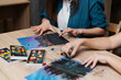 © callisto - Creative individuals engaged in pastel art at a wooden table