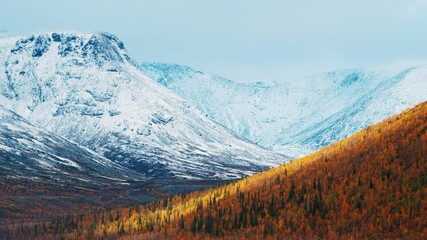 Valley with autumn mountains covered with first snow