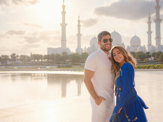 Wall Mural - Travel to the United Arab Emirates, Abu Dhabi. Arab couple visiting the Grand Mosque in Abu Dhabi .