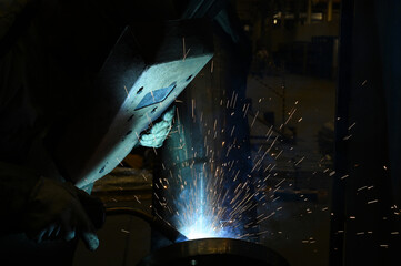 Welding worker working in the factory, welding and joining metals together