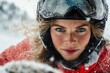 © Milos - A close-up shot captures the intense focus of a snowmobile rider, eyes locked ahead, with freckles visible through her clear visor surrounded by blowing snow.