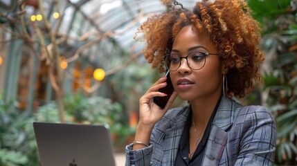 Wall Mural - Woman working on laptop and talking on phone in greenhouse