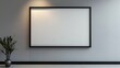 © Rabil - A simple black frame hangs on a light gray wall. The frame is empty, ready for you to add a picture or artwork.