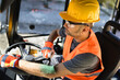 © zphoto83 - Construction worker operating heavy machinery at a job site during daytime wearing safety gear and focusing on the task