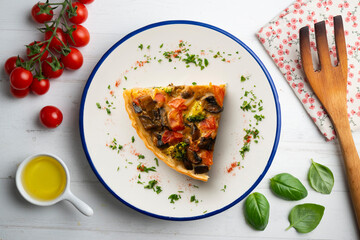 Wall Mural - Piece of roasted vegetarian vegetable quiche. Top view table with decorations.