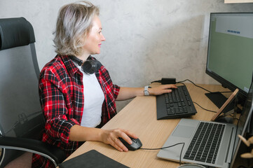 Mature Woman Working from Home Office on Desktop and Laptop