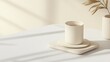 © Chayada - Minimalist beige coffee cup on stacked coasters with soft sunlight and shadows on neutral background