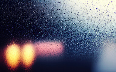 Poster - Close-up of droplets on a glass surface with a blurred background, creating a serene and dreamy atmosphere, perfect for graphy.