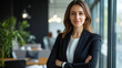 © EmmaStock - A professional business portrait of a woman in formal attire, standing confidently in a modern office setting