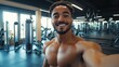 © Johannes - A fitness man is smiling and taking a selfie in a gym.