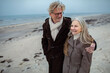© Marko Geber - Elderly couple walking on a beach in winter coats