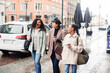 © Davor - Three diverse female friends walking together on city street
