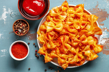 Homemade Trendy Pasta Chips. Crispy Spicy Pasta Farfalle with Tomato Sauce.