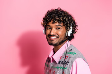 Poster - Portrait of nice young man communicate operator headset wear xmas new year vest isolated on pink color background