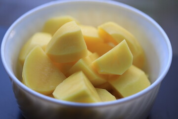 Poster - peeled potato pieces in a white plate.