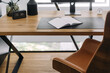© brizmaker - Modern workspace setup with an open notebook on a wooden desk in a bright office environment
