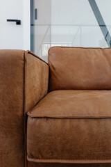 Wall Mural - Cozy brown leather couch in a modern living room interior with minimalistic design