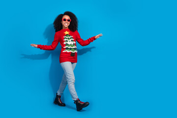 Canvas Print - Full body photo of attractive young woman walk dance sunglass dressed red christmas clothes theme party on blue color background