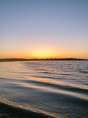 Wall Mural - seascape from kayak with large sunset on the horizon