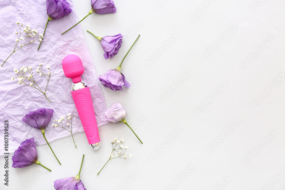 Composition with beautiful flowers and vibrator on white background