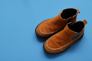 Wall Mural - Pair of stylish child's boots on blue background