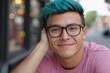 © Halina Berah - Male African American with blue dyed hair and stylish eyeglasses standing in the street and posing for the camera with a bright smile