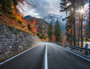 Wall Mural - mountain road at sunset in autumn. alps, italy. beautiful winding alpine road, snowy rocks, trees, r