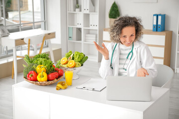 Poster - Mature female nutritionist with laptop video chatting at table in office