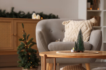 Wall Mural - Small Christmas trees, wicker mat and lamp on table in living room