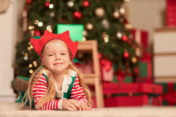 Poster - Cute little girl in elf costume writing letter to Santa at home on Christmas eve