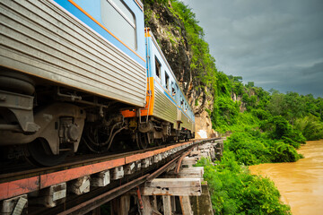 Trains running on death railways track crossing kwai river in kanchanaburi thailand this railways important destination of world war II history builted by soldier prisoners.