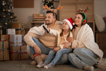 Sticker - Little girl with her parents watching Christmas movie at home