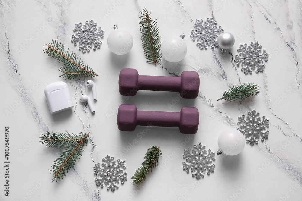Composition with dumbbells, earphones and Christmas decorations on light background
