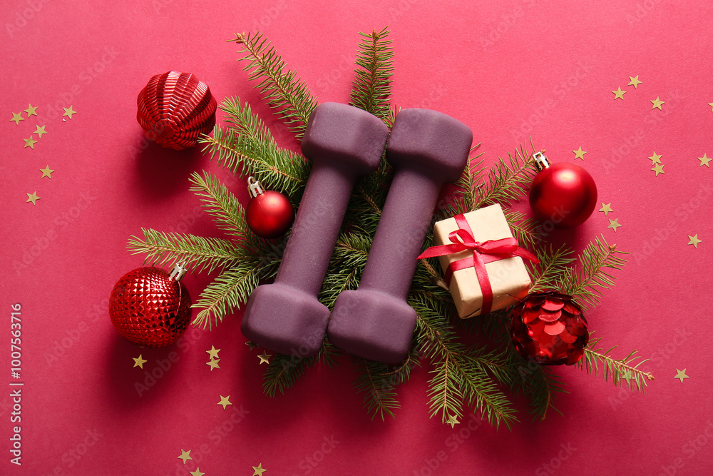 composition with dumbbells, Christmas decorations and fir branches on red background