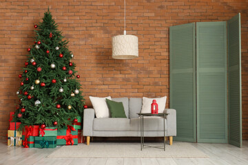 Interior of living room with Christmas tree, sofa and folding screen