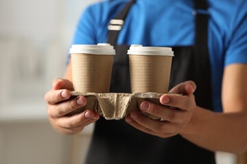 Canvas Print - Fast-food worker with paper cups indoors, closeup