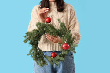 Sticker - Young woman with Christmas wreath on blue background