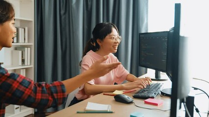 Slow motion back end software developer engineer for computer programming working together on debugging writing computing code, solving complex algorithms display on monitor in office. Burgeoning