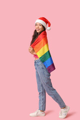 Poster - Young Asian woman in Santa hat with LGBT flag on pink background. Christmas celebration