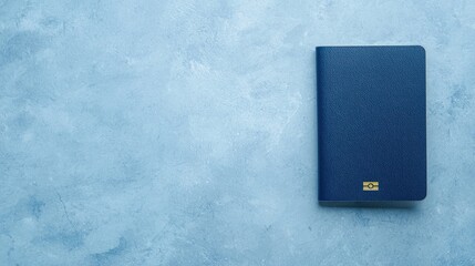 A textured navy blue notebook rests on a light blue surface, showcasing a minimalist design and simple elegance.