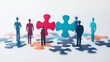 © Vertigo Images - Paper figures stand on puzzle pieces, symbolizing teamwork.