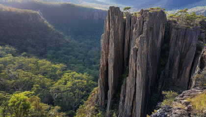 Wall Mural - A breathtaking view of towering rock formations amidst lush greenery in a mountainous landscape.