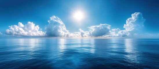 Wall Mural - Sunny day with white clouds reflected on the blue ocean.