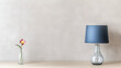 © Bi - Minimalist design with a blue lamp, a single flower in a glass vase, and simple geometric decor, creating a calm, modern atmosphere.