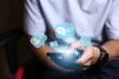 © arneaw - Close-up of man's hand using smartphone to play social media with emoticons or notifications popup.
